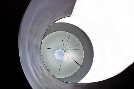 Photographie abstraite d’escalier circulaire vue en contre-plongée aux formes géométriques