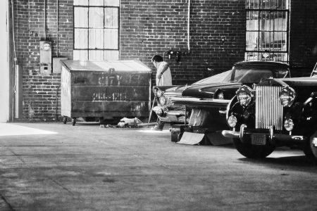 Ouvrier qui balaye dans un garage automobile à Los Angeles