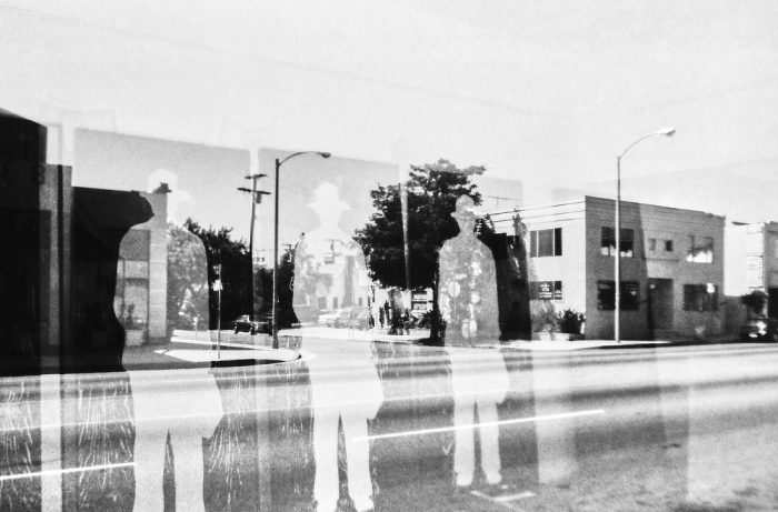 Silhouettes dans une vitrine, reflets d'une rue déserte de Los Angeles