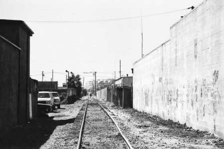 Homme marchant sur une voie ferrée désaffectée, série alone in la