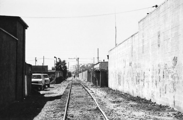Homme marchant sur une voie ferrée désaffectée, série alone in la