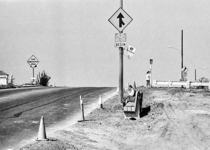 Femme qui attend le bus assise sur un banc
