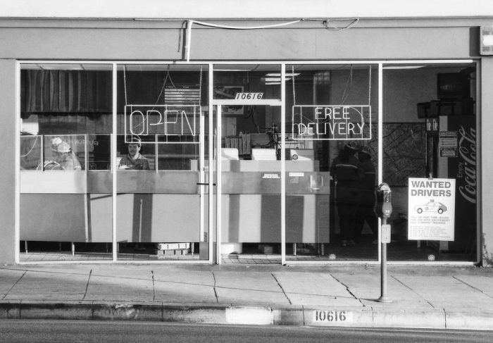 Un serveur attend le client derrière la devanture de son commerce, Alone in LA